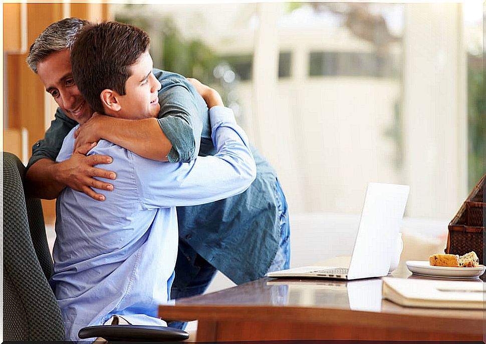 Father giving a hug to his teenage son.