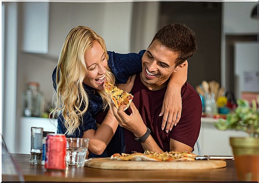 A very happy couple eats pizza. 