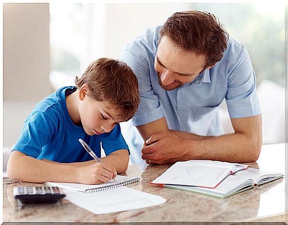 Portrait of a happy man helping his son to do homework - Indoor