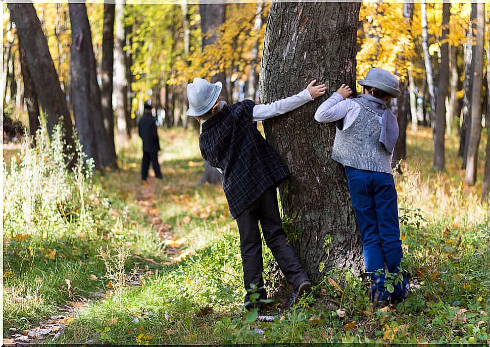 Detective children watching from behind a tree.