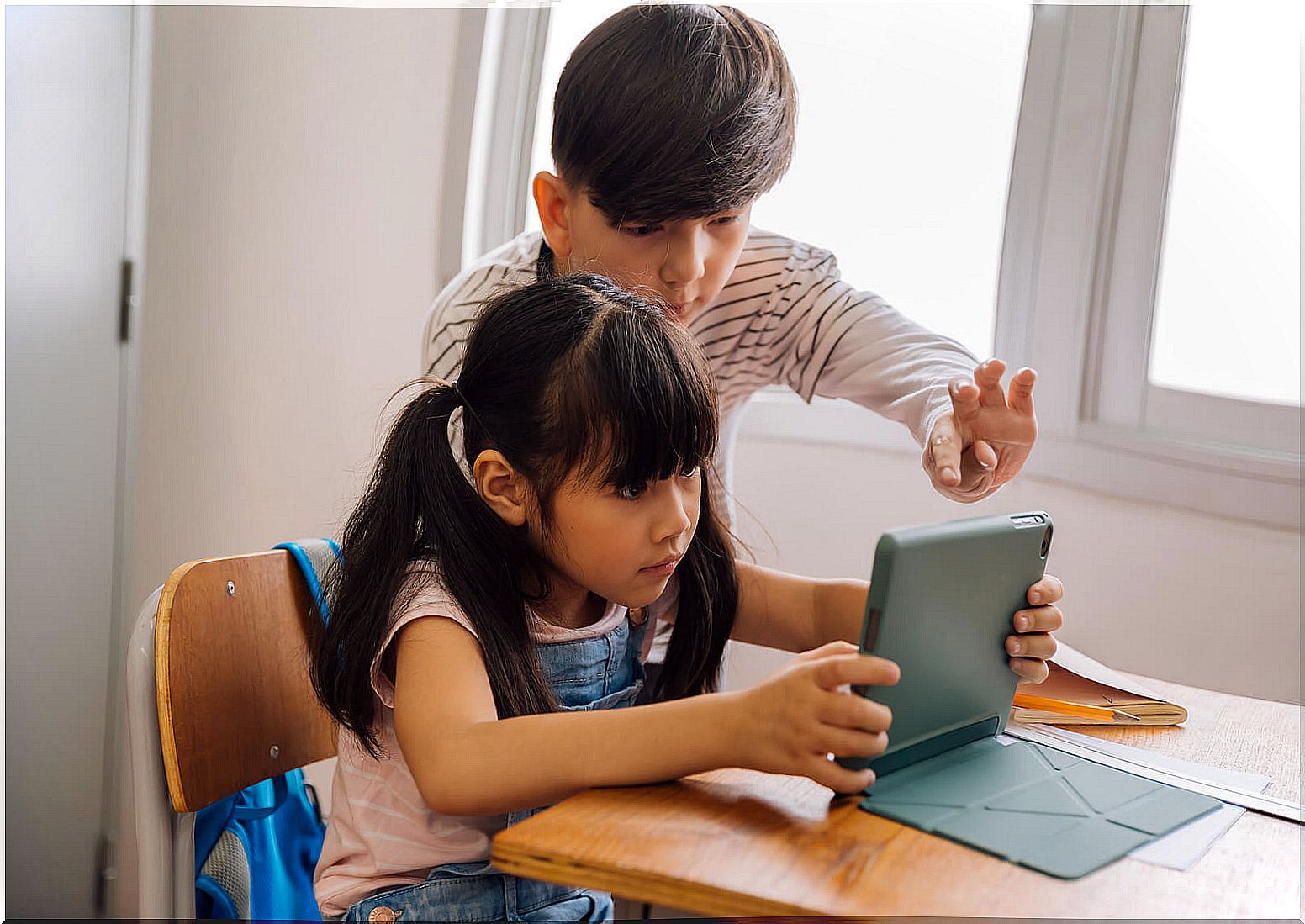 Digital native children consulting information on the tablet.