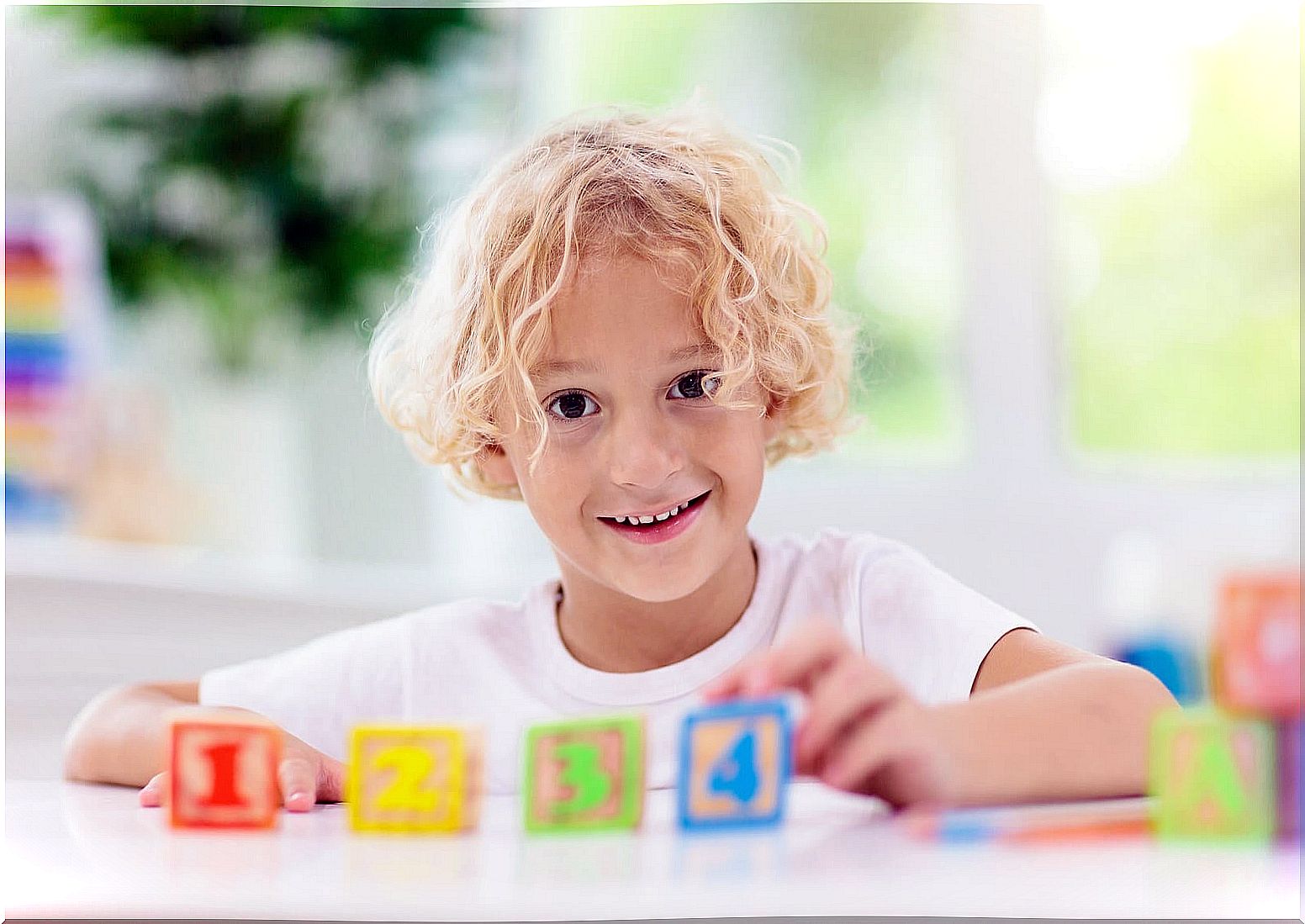 Child with some wooden cubes with numbers.