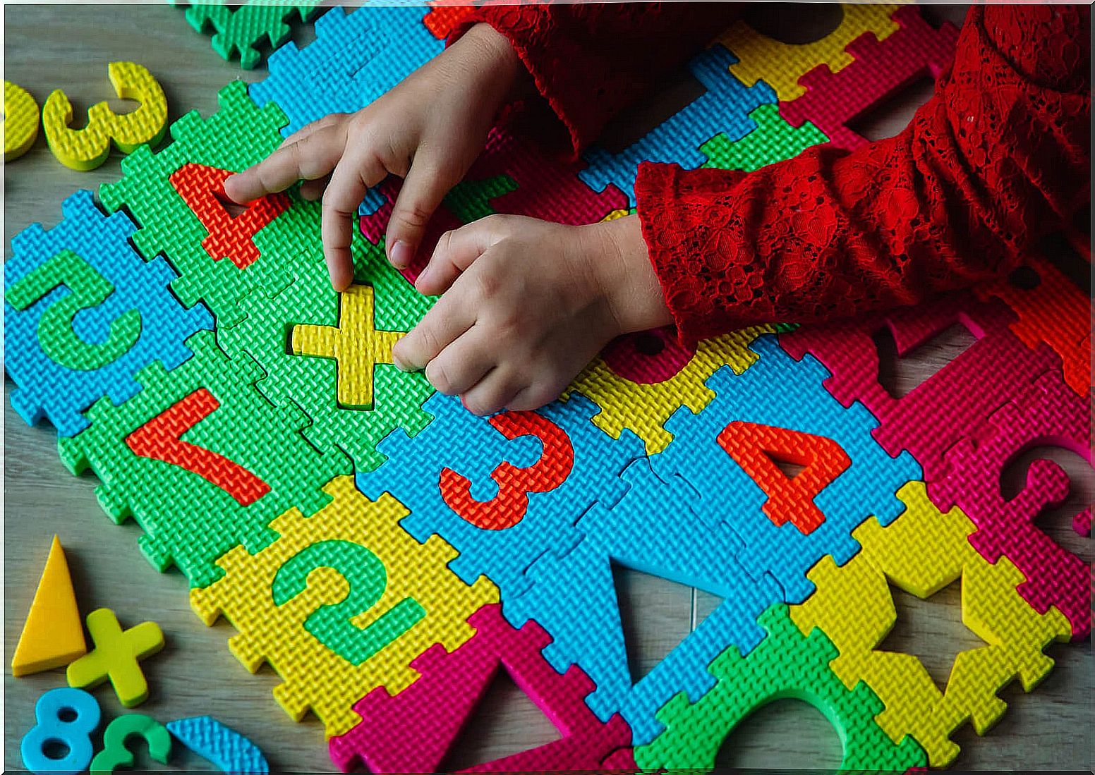 Child playing on a mat with numbers because knowing how to count does not imply knowing them.