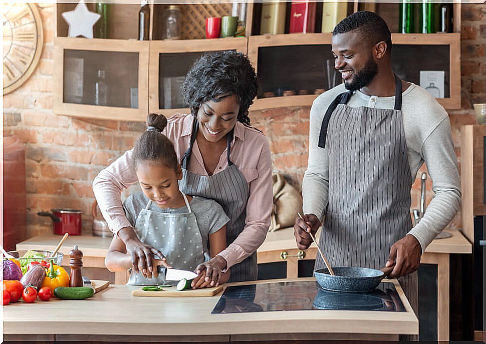 Parents cooking with their daughter as part of family life.