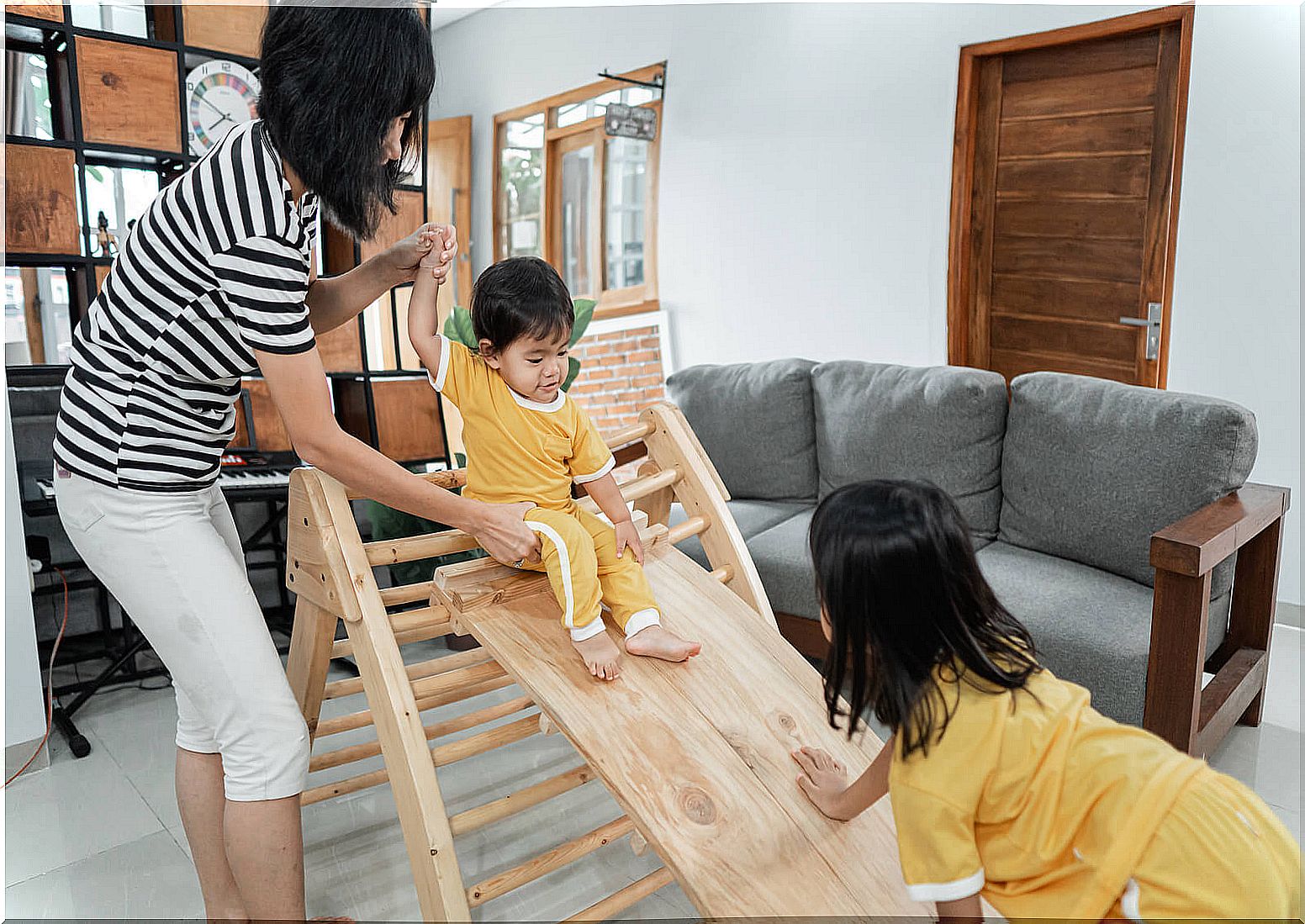 Mother with her children applying the Pikler method to promote free movement in babies.