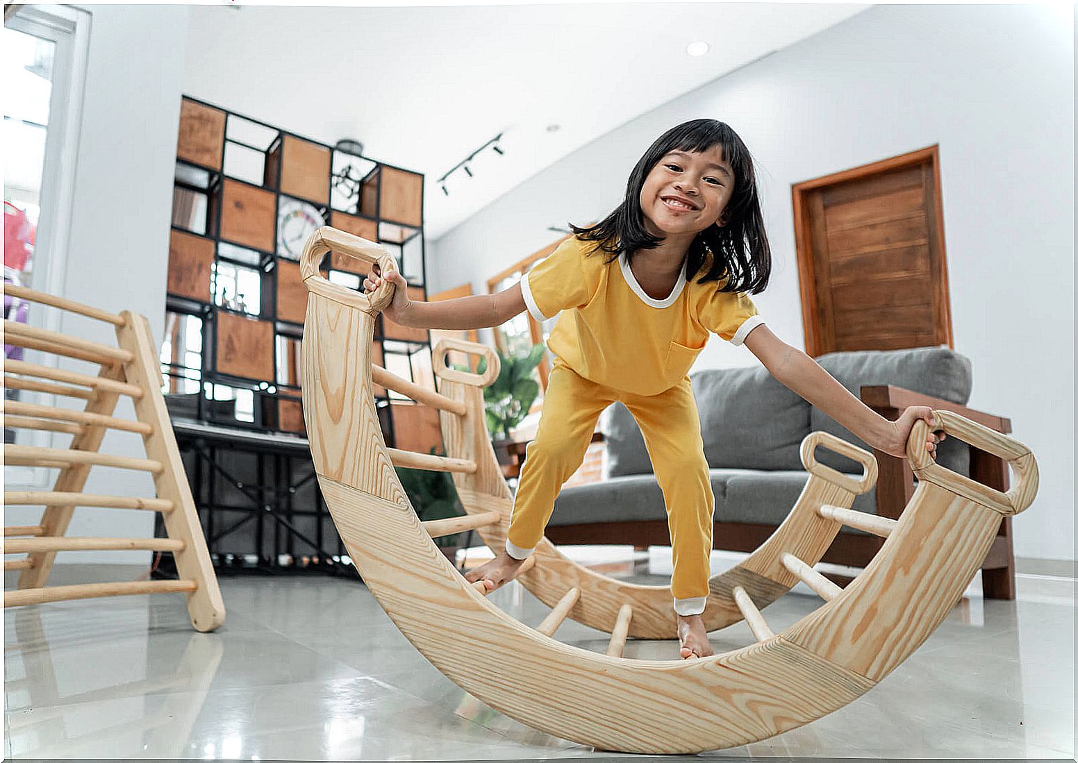 Girl playing with elements of the Pikler method.