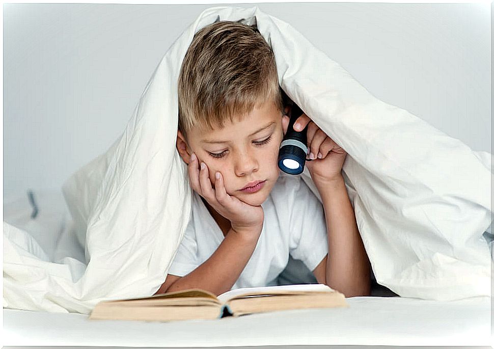 Child studying in bed, one of the worst study habits.