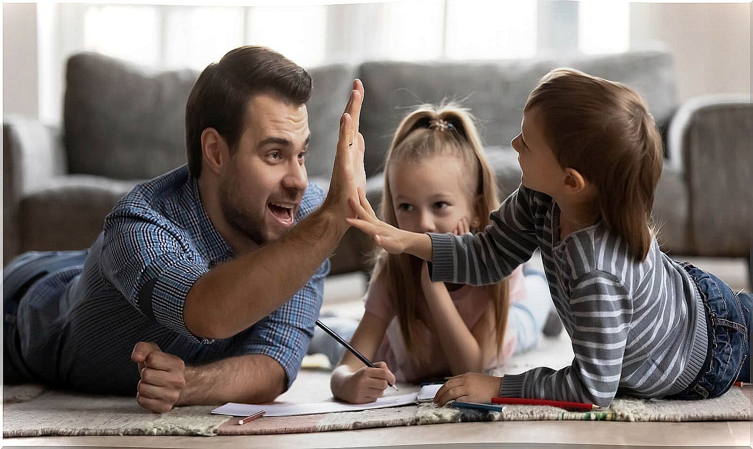 Father high-fiving his son as part of using praise as prizes and rewards for children.