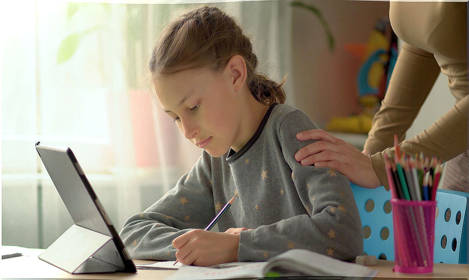 Mother supporting her daughter while studying at home.