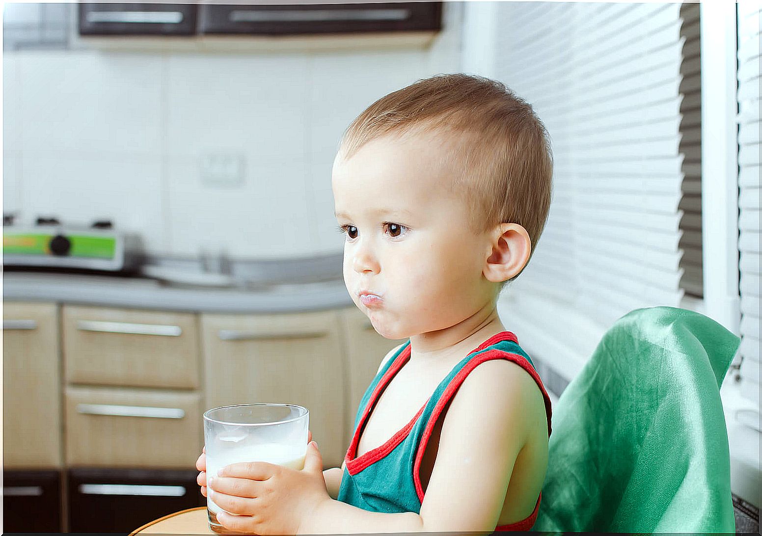 Child drinking a glass of milk.