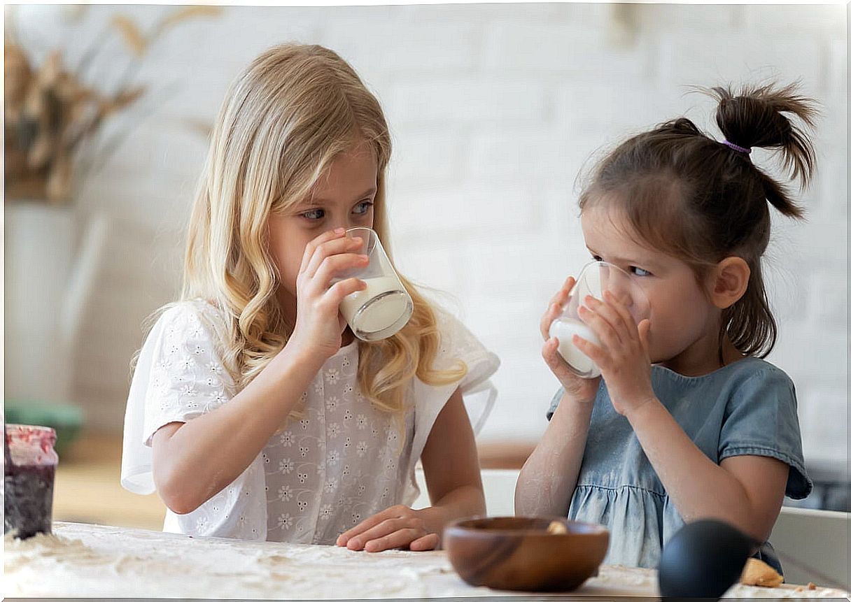 Girls having a glass of milk according to the appropriate amount for their age.