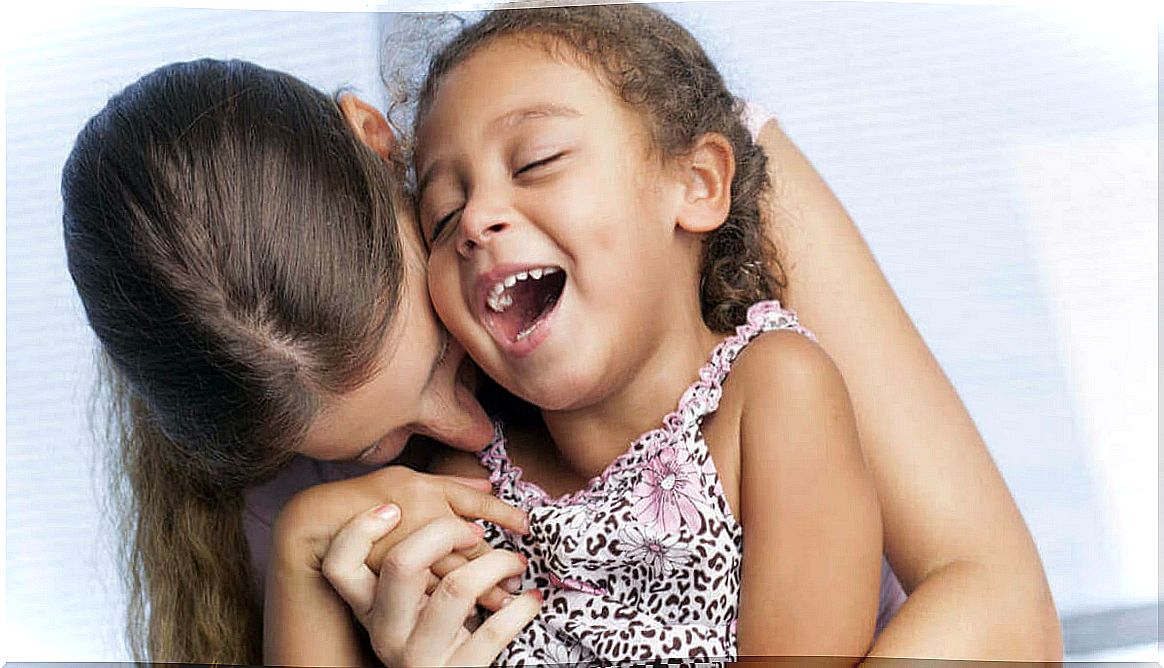 Mother giving her daughter a kiss on the cheek.