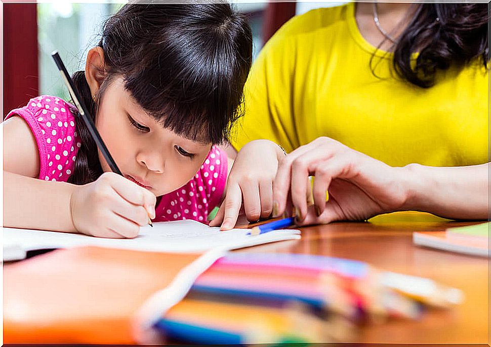 Chinese mother homeschooling her child teaching her daughter to write