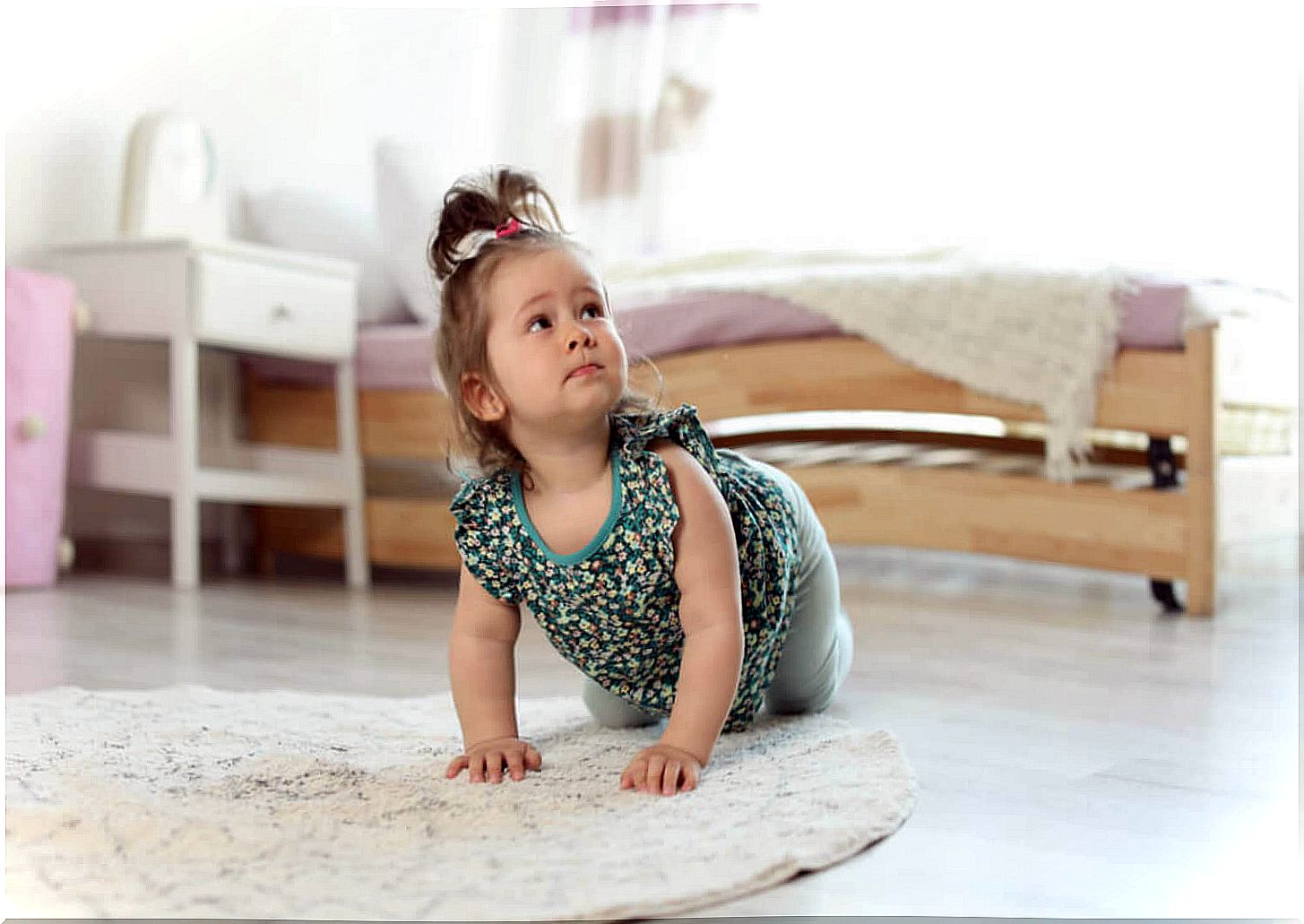 Little girl learning to crawl on the floor.