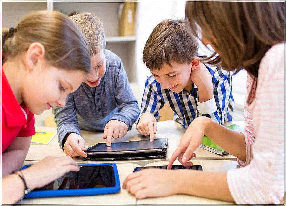 Children with tablets using technology in the classroom.