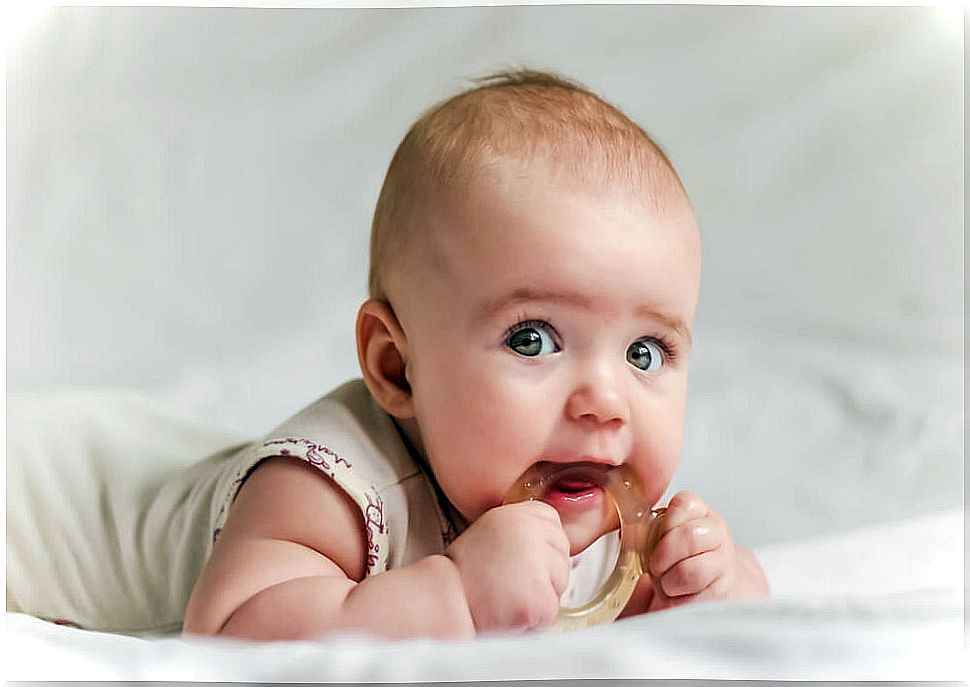 Baby with a teether because his teeth are coming out.