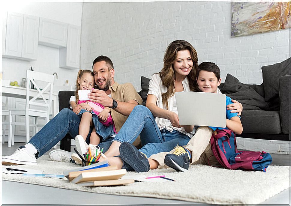 Parents with their children watching the educational content of the We Learn at Home initiative.