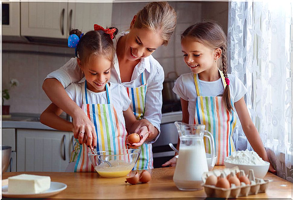 Mother cooking with her daughters during coronavirus isolation.