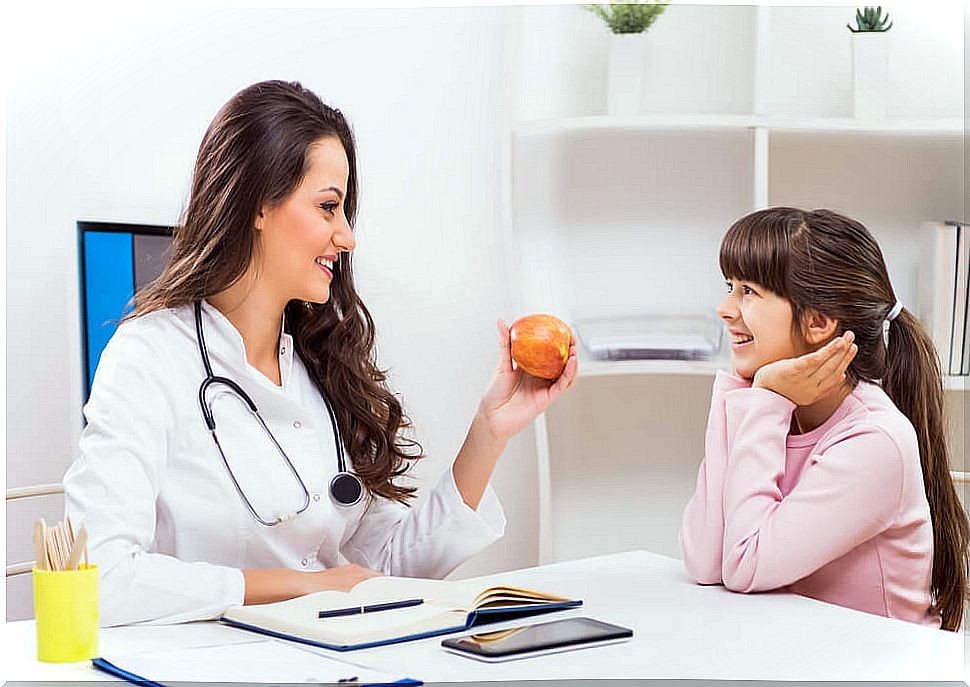 Girl talking to nutritionist about eating fruits and vegetables.